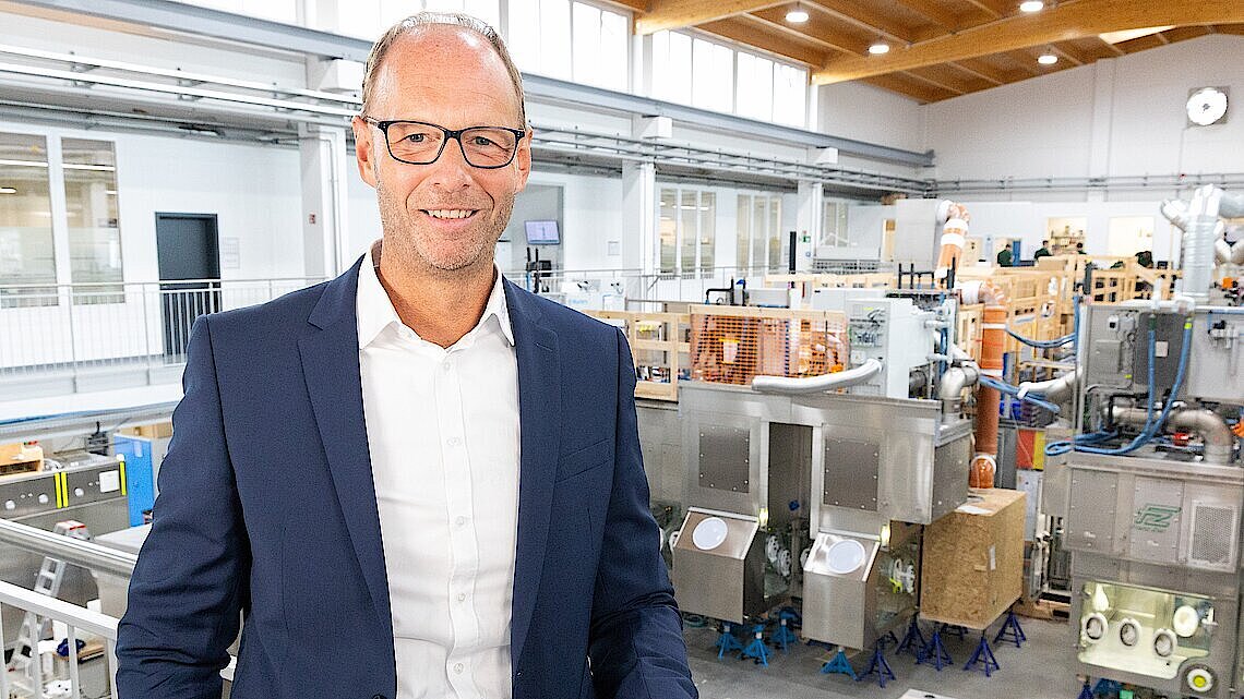 Shows the managing director Olaf Ziel in long shot in front of the Körber production floor.